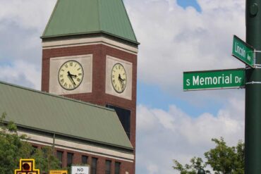 Lancaster's iconic clock tower with street signs under a clear blue sky